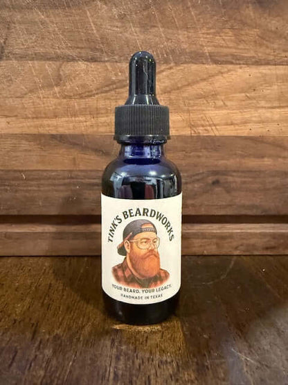 The Lumberjack "Premium Beard Oil - Woods Blend 1oz" bottle by Tink's Beardworks on a wooden background.